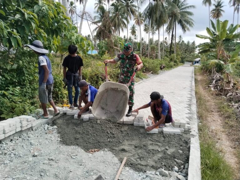 Anggota Koramil 1307-05/Ratolindo, Koptu Mahyuddin Laksanakan Komsos dengan Membantu Warga Pasang Paving Block