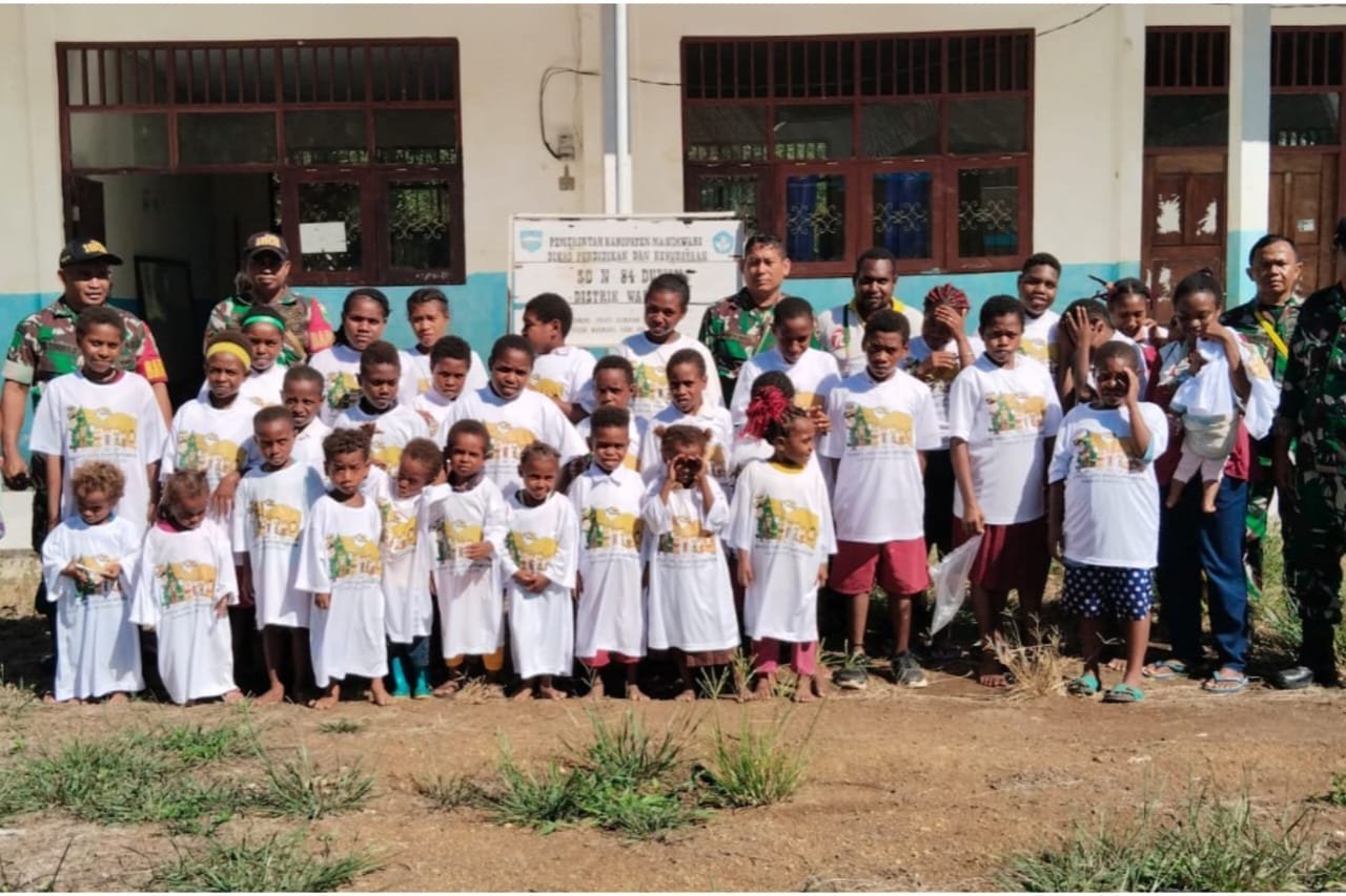 Kado Natal Dari Kasad, Koramil 1801-02/Warmare Bagikan Bingkisan Kaos Natal Kepada Siswa SD 84 Duwin