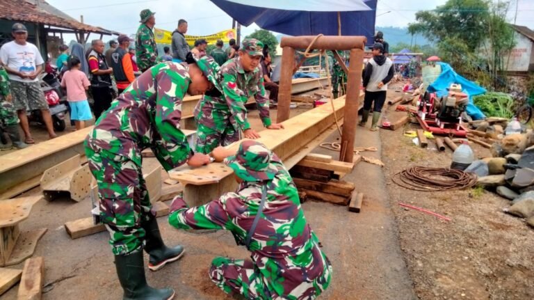 Babinsa Koramil 06/Tersono Bantu Perbaiki Jembatan Kalibelo Yang Rusak Akibat Banjir Bandang