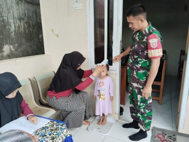 
					Babinsa Koramil 1426-03/Galut Dampingi Petugas Posyandu Lakukan Penimbangan Balita