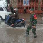 Pasca Hujan Lebat, Babinsa Kodim 1425 Jeneponto Monitoring Banjir di Jl. Poros Jeneponto – Bantaeng