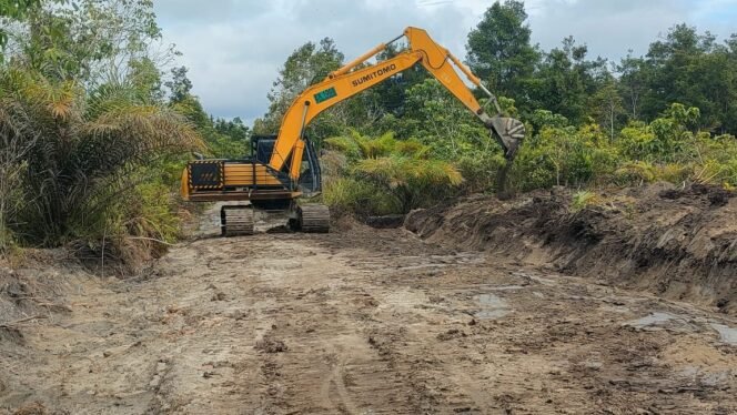 
Satgas TMMD Lakukan Pelebaran Jalan, Excavator Sisir Pinggir Jalan Desa Wungkur Baru