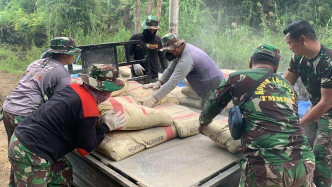 
Tentara dan Warga Bersama-sama Angkut Material Pengecoran Jalan Desa Talio