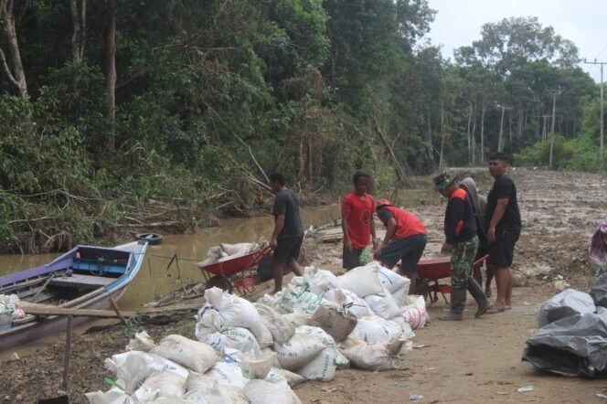
					Satgas TMMD ke-124 dan Warga Angkut Material Bangunan di Jalan Desa Talio