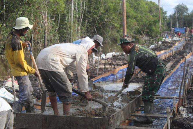 
					Semangat Gotong Royong Warga dan Satgas TMMD Aduk Material di Desa Talio