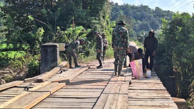 
					Anggota Satgas TMMD 125 Kodim 1417/Kendari Pasang Papan Roda Pada Jembatan