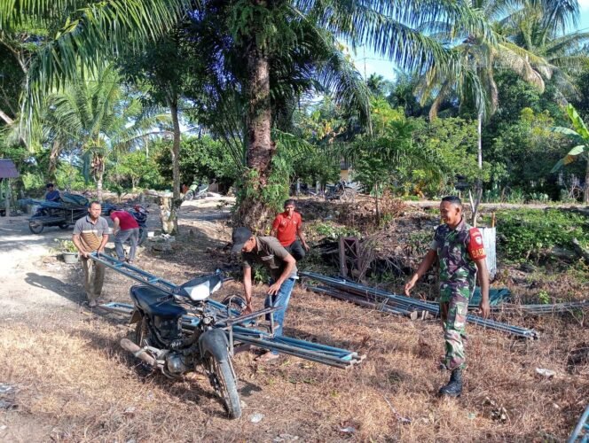 
Babinsa Sampoiniet Serda Iswadi Bergotong Royong Bantu Warga Pasang Tenda Hajatan dan Pererat Silaturahmi