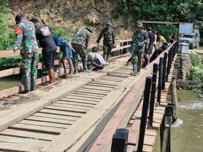 
					Gotong Royong Anggota TMMD 126 dan Warga Desa Tanggauna, Laksanakan Pengecatan Dasar pada Tiang Jembatan