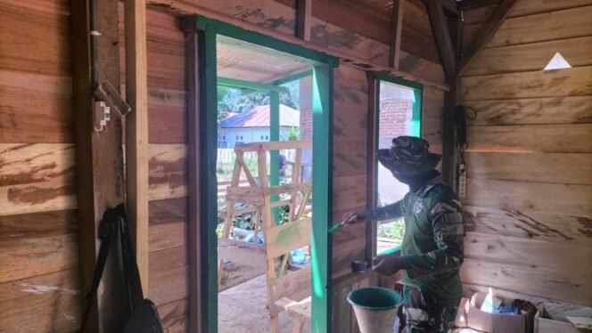 
					Anggota Satgas TMMD ke-126 Lakukan Pengecatan Tembok Rumah RTLH di Desa Uessi