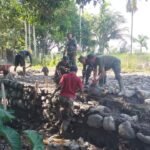 Satgas TMMD dan Warga Susun Batu Sungai Jadi Benteng Jalan