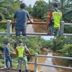 Babinsa dan Warga Pantau Debit Air Sungai Antisipasi Bahaya Banjir