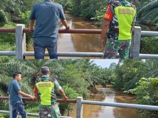 Babinsa dan Warga Pantau Debit Air Sungai Antisipasi Bahaya Banjir