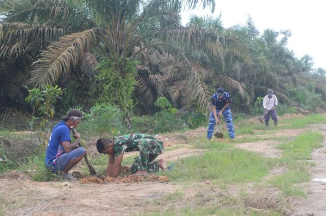 
					Masyarakat Bersama Prajurit Satgas TMMD ke-128 Gotong Royong Gali Lubang untuk Penanaman Pohon