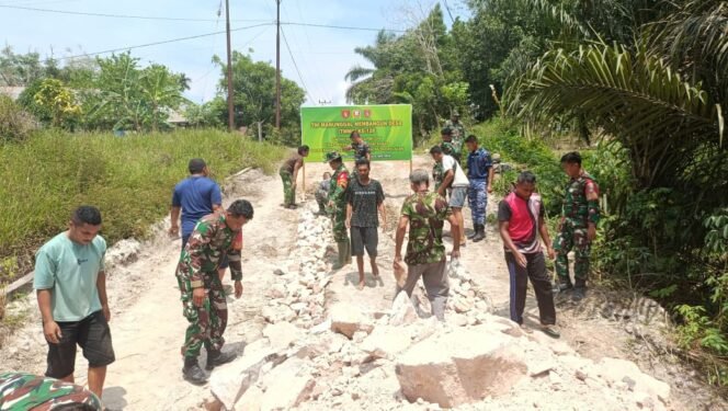 
					Bahu Membahu, Satgas TMMD 128 dan Warga Ratakan Jalan Desa