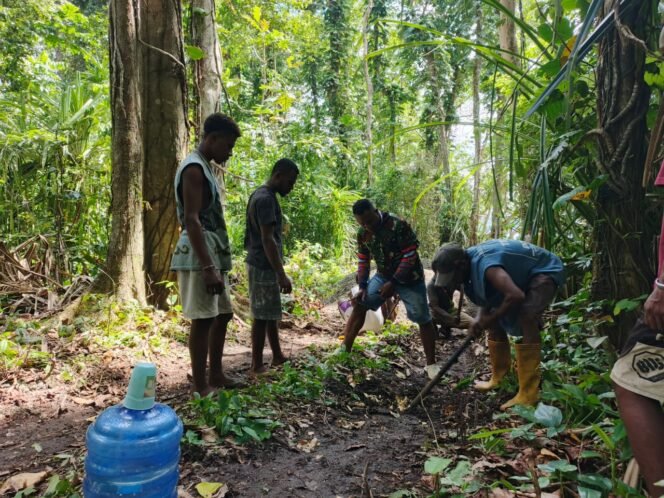 
					Manunggal dengan Rakyat, Babinsa Kodim 1801/Manokwari Bantu Warga Ratakan Jalan TMMD ke-128